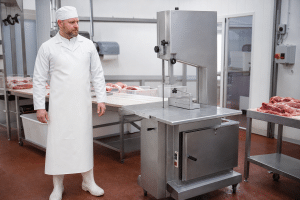 Commercial bone saw machine in a clean butcher preparation area