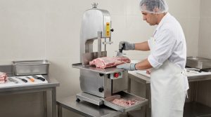 Commercial meat band saw set up for controlled cutting of bone-in meat